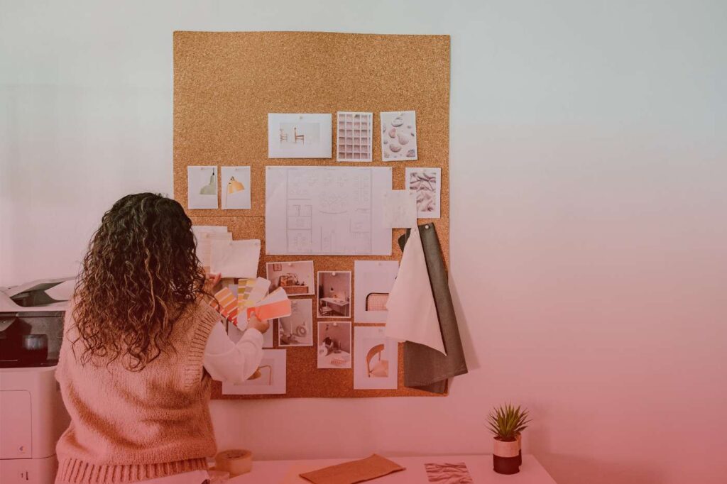 A woman organizing plans on a bulletin board while preparing for a spring relocation.