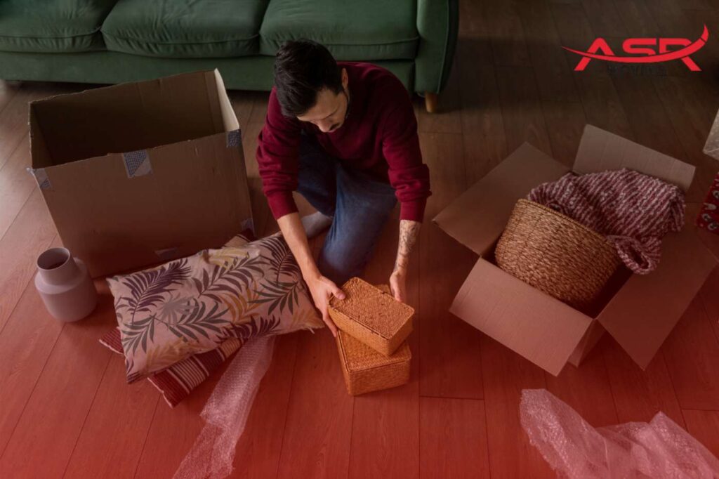 Person packing soft items like pillows and blankets into a moving box
