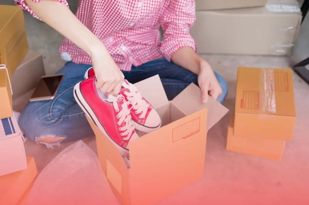 placing red sneakers into a box